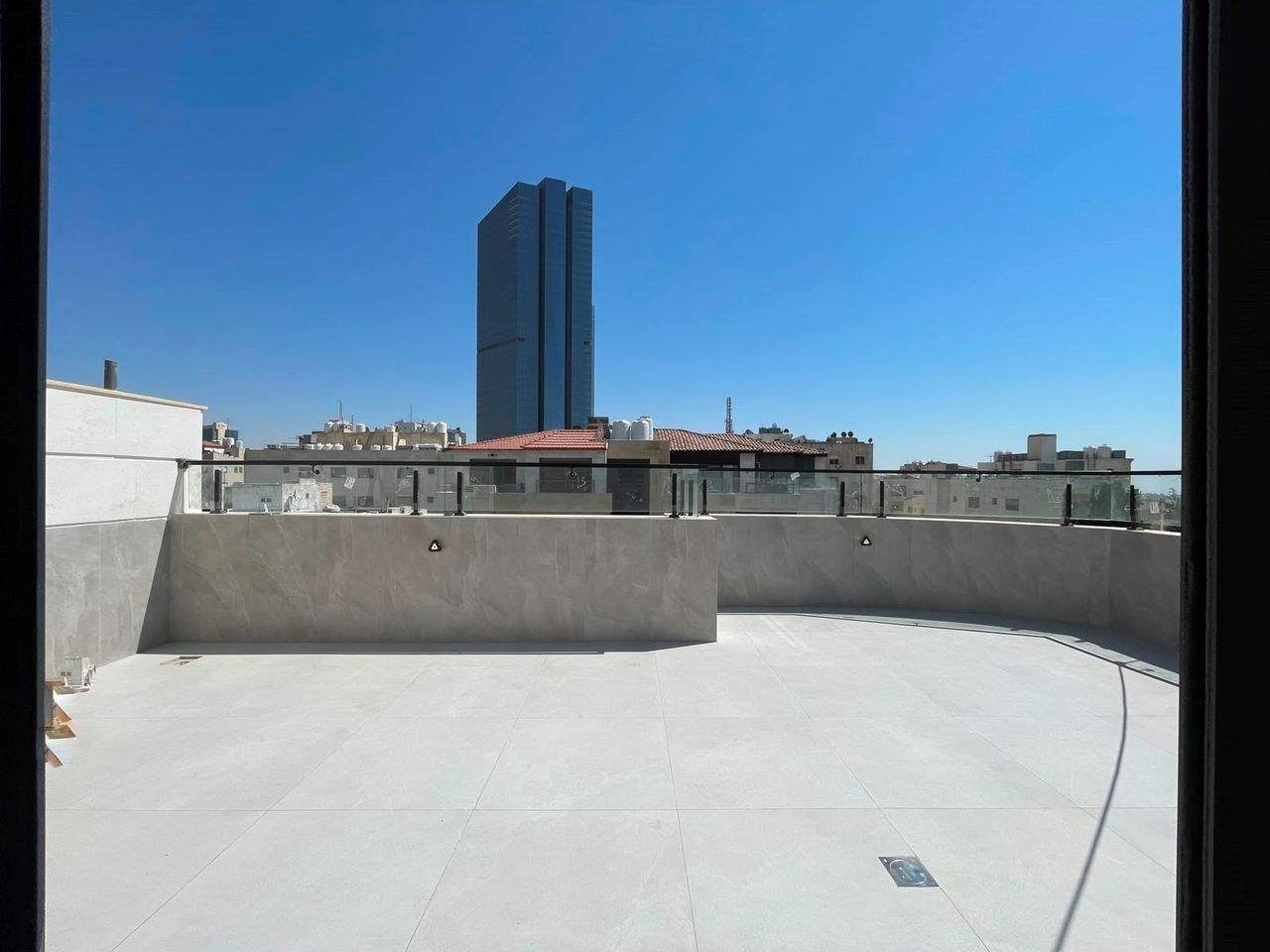 A roof terrace above the building, looking out over Amman.